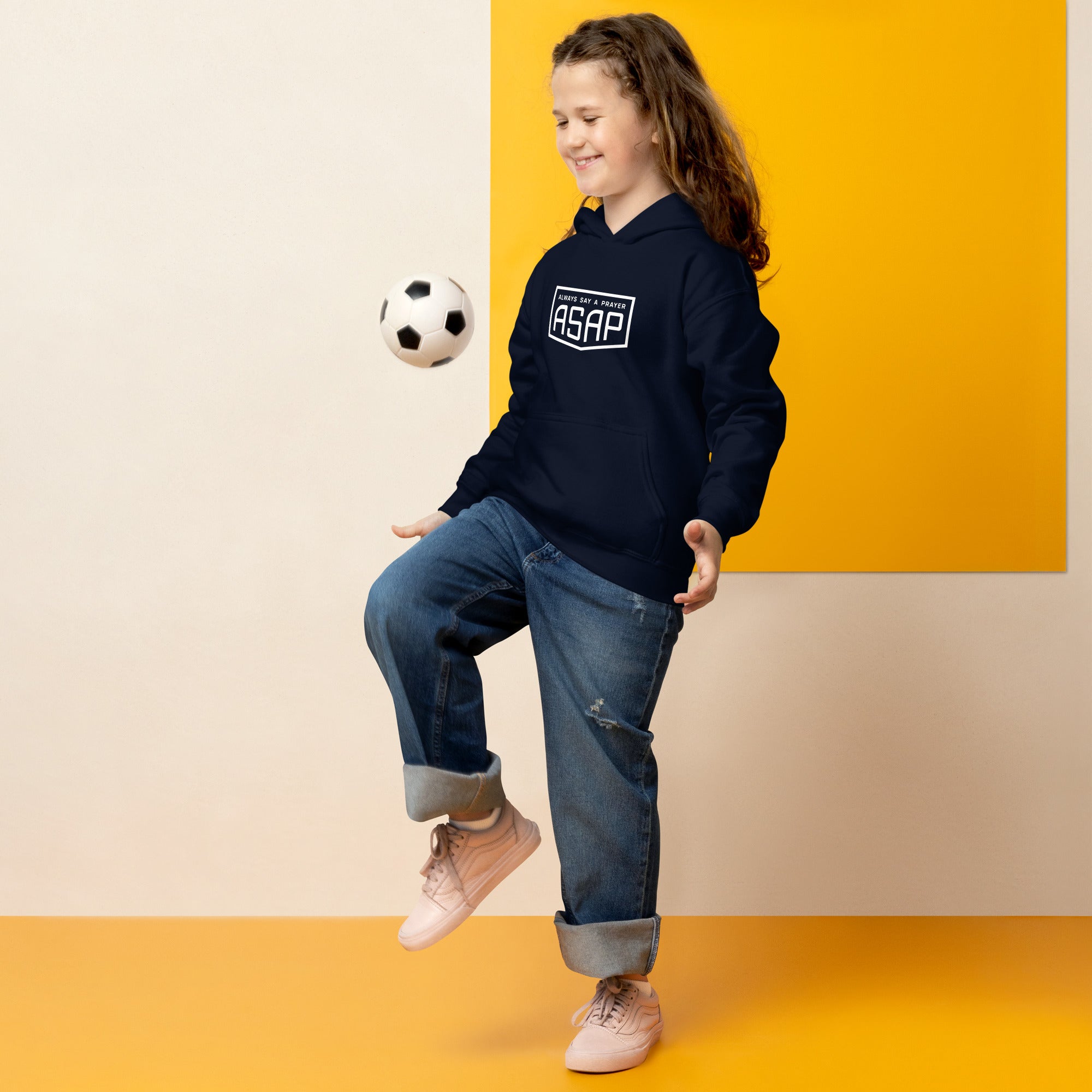 young girl playing football wearing a heavy blend hoodie navy blue with white asap print